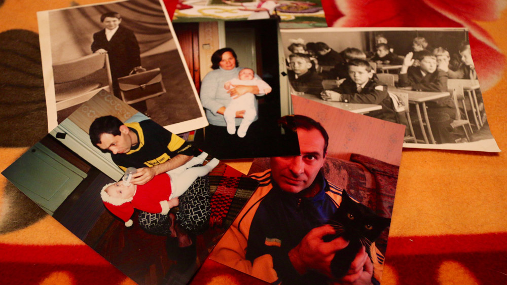 Sergey loved cats and gave his mother her two pets. The black and white photos show him on his first day at school. He's also shown feeding his newborn daughter, who is held by Ekaterina in the middle [Philippa H Stewart/Al Jazeera]