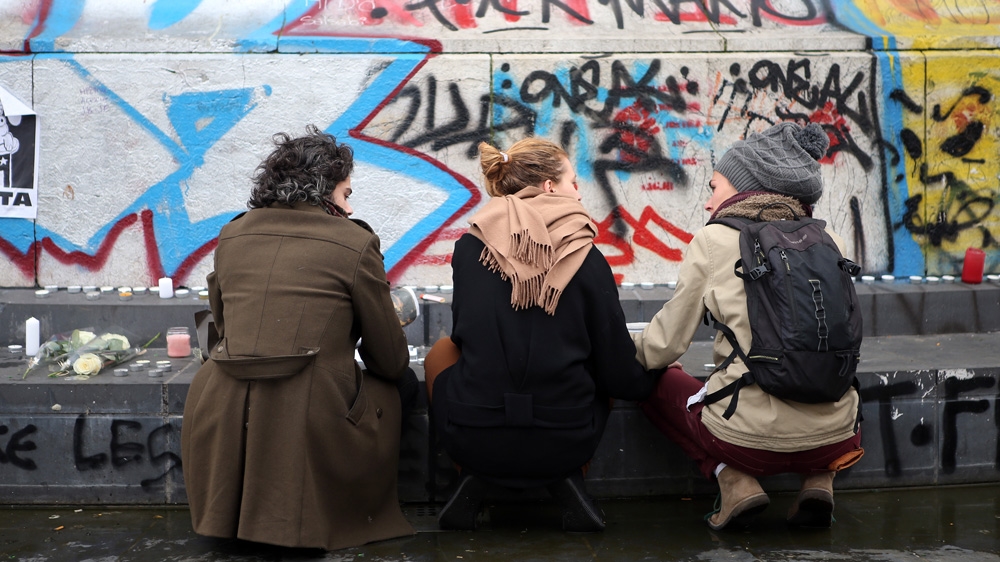 Antoine Goupil, left, a 26-year-old schoolteacher, mourns with friends at Place de la Republique, the day after the Paris attacks [Maya Vidon-White/Al Jazeera]