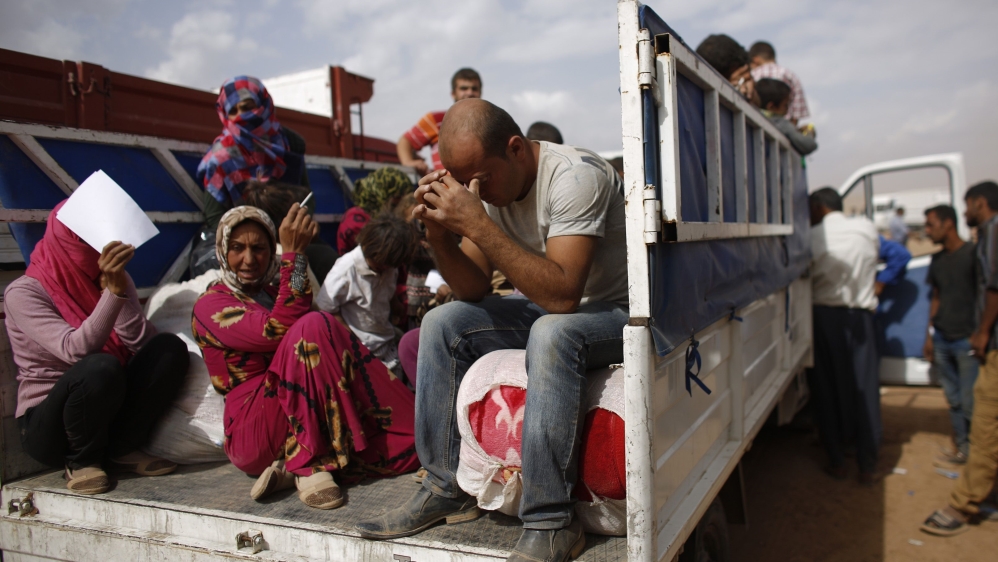 File photo of Syrian Kurdish refugees sitting in a truck after crossing the Turkish-Syrian border near the southeastern town of Suruc in Sanliurfa province
