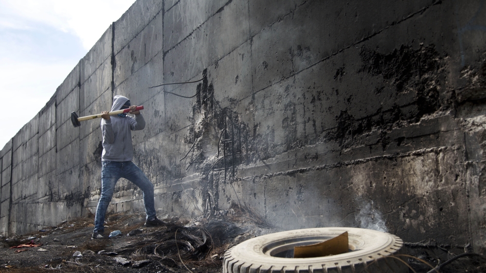 A Palestinian student tries to break the separation barrier
