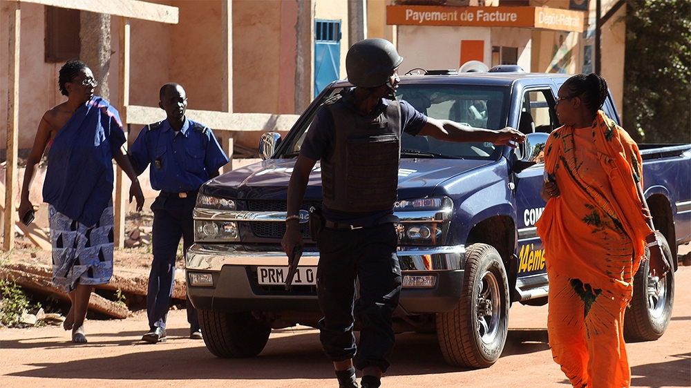 Malian security forces evacuate two women from the area surrounding the Radisson Blu hotel on Friday [Habibou Kouyate/AFP]