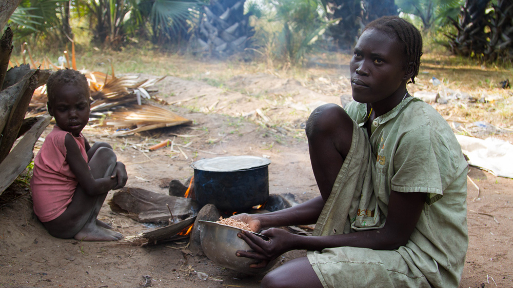 
Internally displaced people on the island of Nyoat cook with what's given to them by relatives in the town of Nyal [Caitlin McGee/Al Jazeera]

