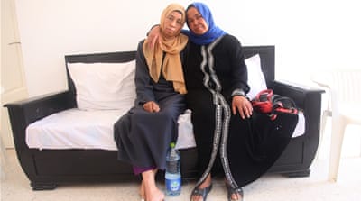 Houria Beji and her younger sister, Awatif, sit in the waiting room of the Cancer Patients Association in Gabes. Houria has been diagnosed with liver cancer and her sister suffers from high blood pressure, blindness in her right eye and diabetes. They believe the plant has caused these health issues [Thessa Lageman/Al Jazeera]
