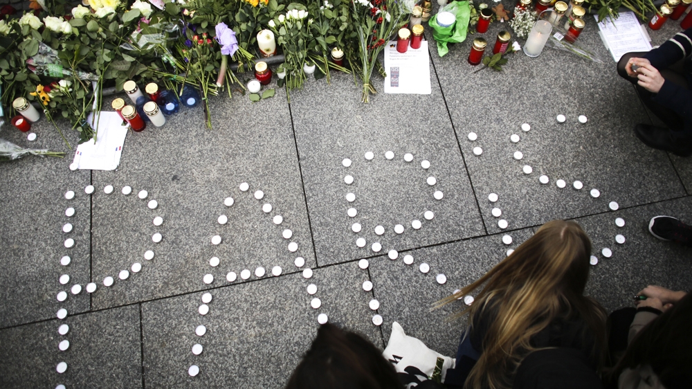 Young women have formed the word Paris with candles to mourn for the victims killed in Friday''s attacks in Paris, France.