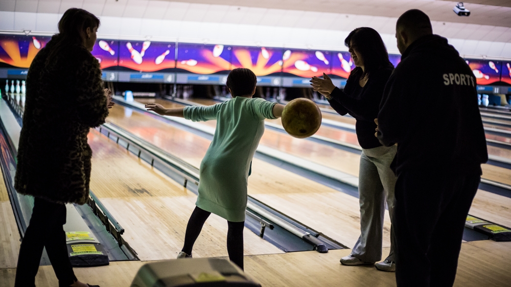 Honey, Louise, Andy and Sharon at a bowling alley as part of the support and respite service Sharon now provides for other families coping with FASD [Michael Mowbray/Al Jazeera]