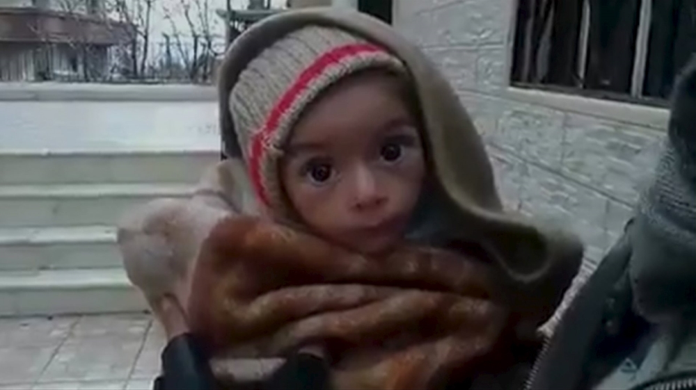 A toddler is held up to the camera in this still image taken from video said to be shot in Madaya