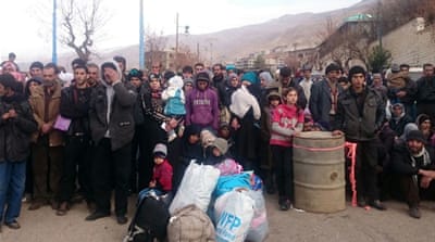 Syrians wait for the arrival of an aid convoy on January 11 [AFP]