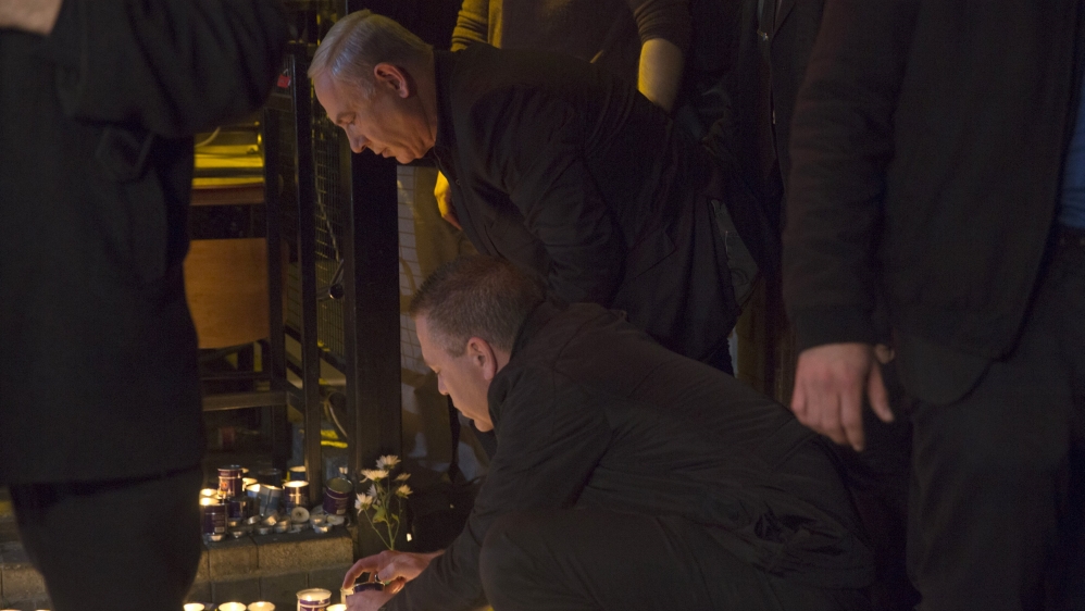 Israeli Prime Minister Benjamin Netanyahu lights a candle during a visit to the scene of a shooting incident in Tel Aviv, Israel
