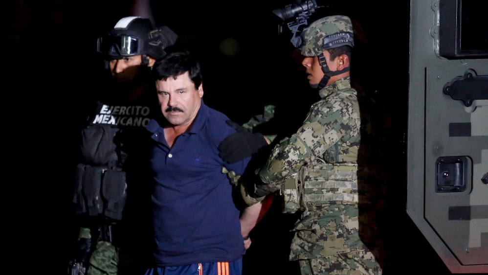 Joaquin "El Chapo" Guzman is escorted by soldiers during a presentation in Mexico City