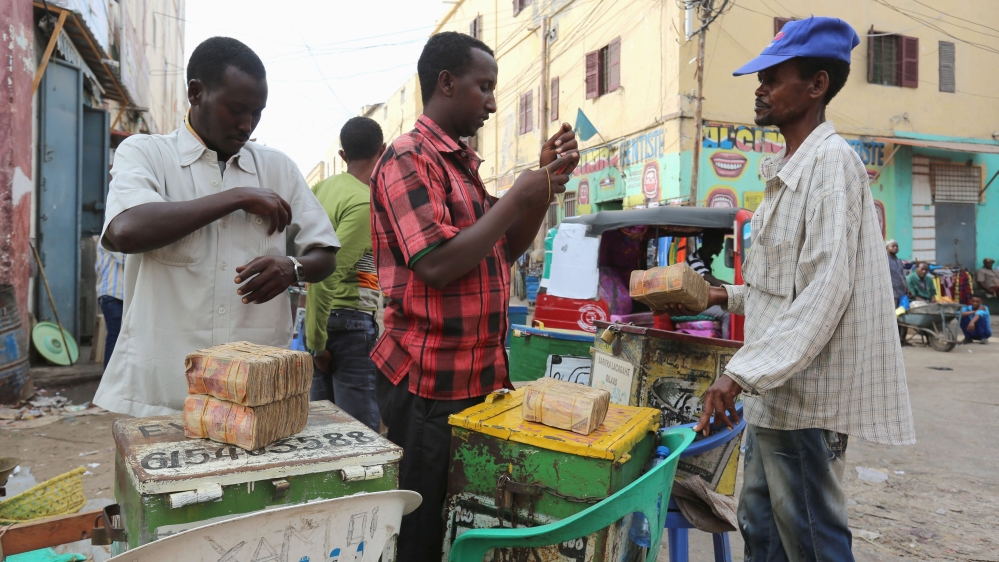 Dealers wait for clients as they trade with bundles of Somalian currency from at an open forex bureau along Hamarweyne district of in Somalia''s capital Mogadishu [REUTERS]