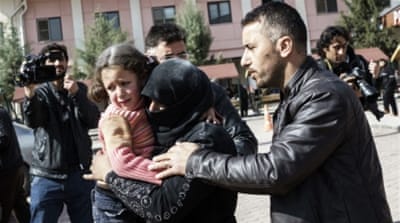 A Turkish man helps a Syrian woman carrying a wounded Syrian girl to a hospital in Kilis, Turkey [AP] 