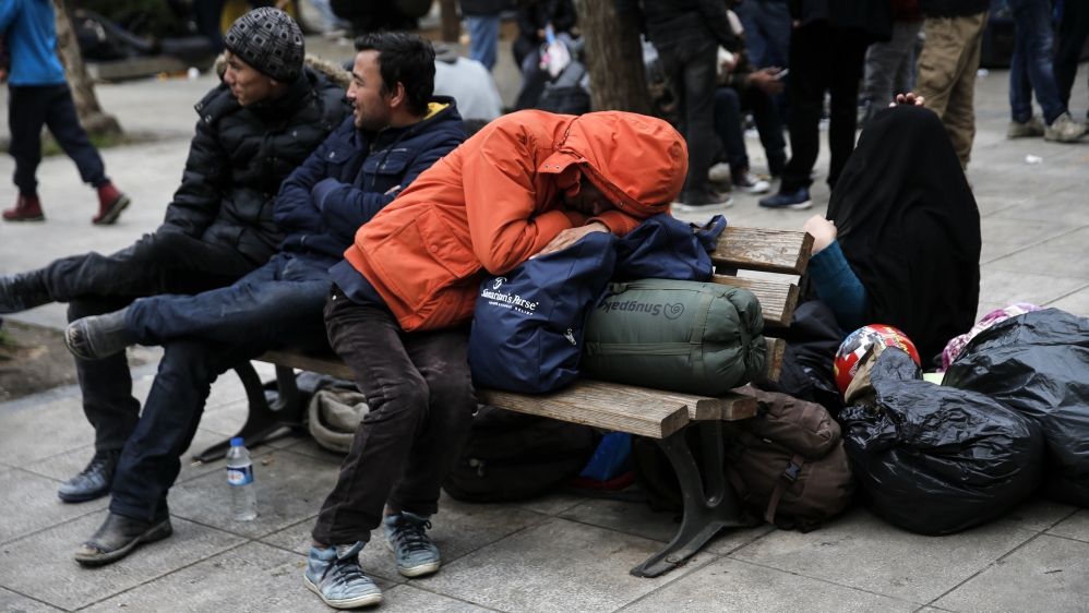 A stranded Afghan migrant sleeps on his belongings on Victoria square in Athens