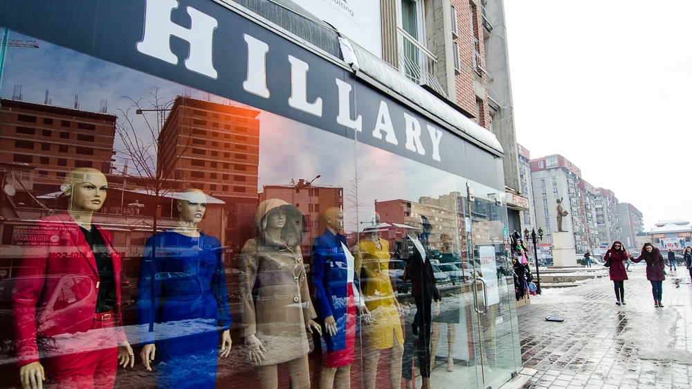 The storefront of the 'Hillary' boutique in downtown Pristina; the Bill Clinton statue can be seen in the distance [Valerie Plesch/Al Jazeera]