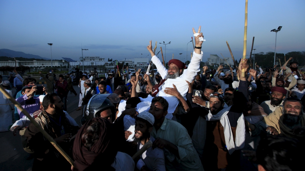 Islamist activists carry one of their party leader on their sholders during a sit in protest against the execution of Mumtaz Qadri outside the Parliament building in Islamabad