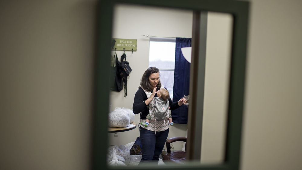 A typical day, Rebecca says, will see her bringing Zach to work for six to seven hours; he nurses, he naps, he plays in his Pack and Play [James Brosher/Al Jazeera]  