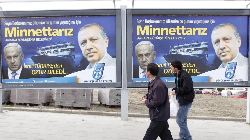 Pedestrians look at billboards with the pictures of Turkey''s Prime Minister Erdogan and his Israeli counterpart Netanyahu in Ankara