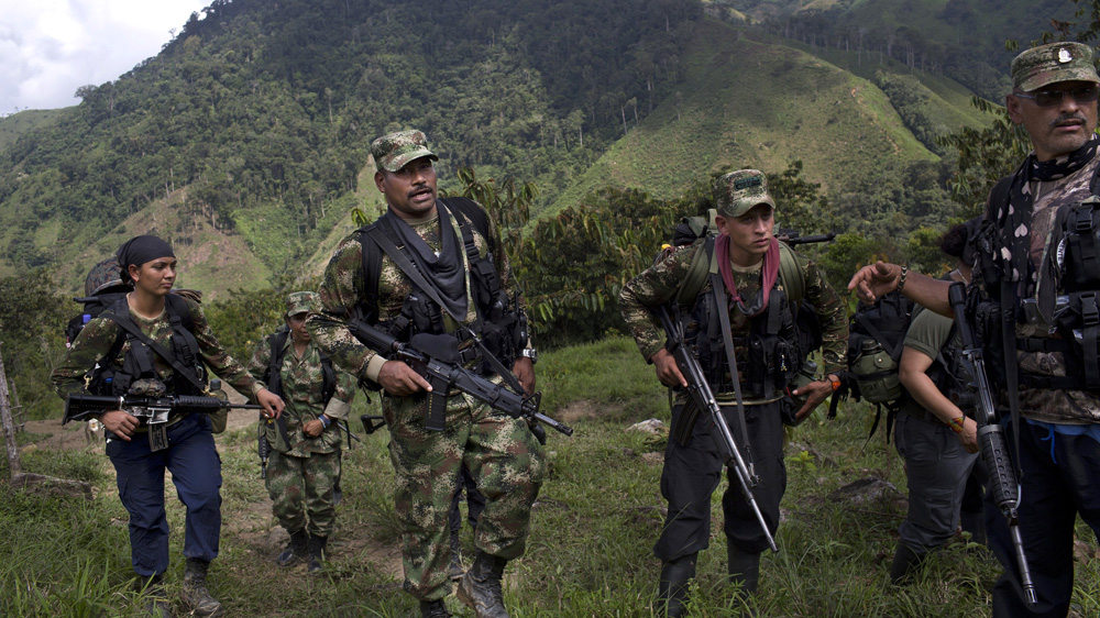 Juan Pablo, a commander of the FARC walks with his comrades in the northwest Andes of Colombia. [Rodrigo Abd/AP]