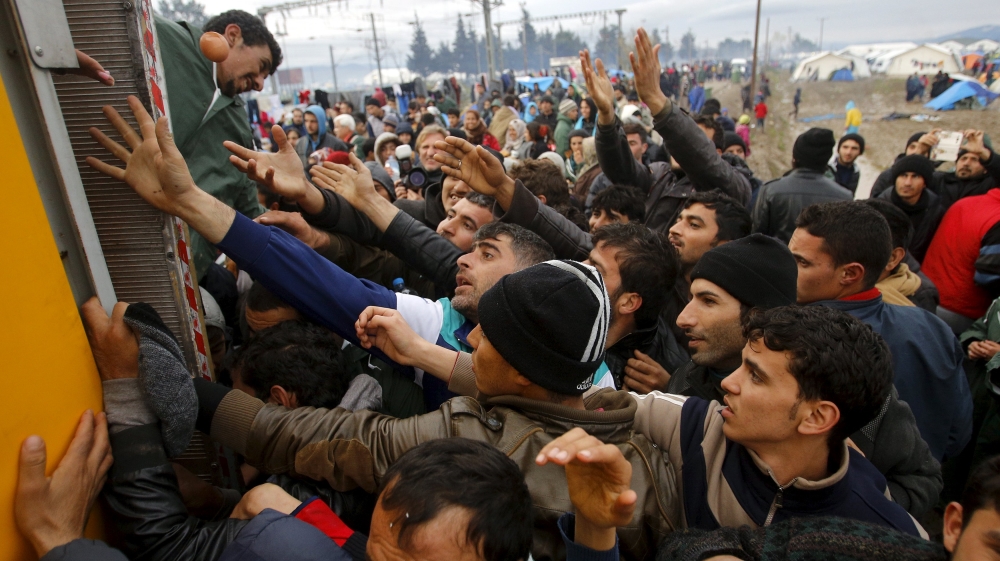 Refugees gather as they try to get products from a truck Idomeni
