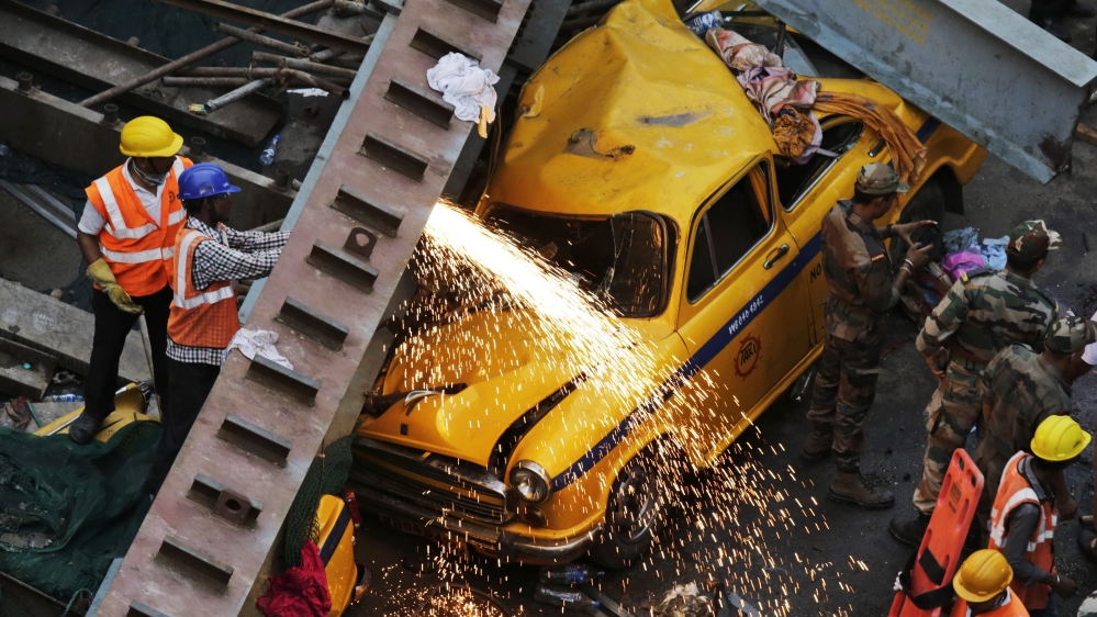 Rescue workers cut through parts of the overpass to recover vehicles [AP]