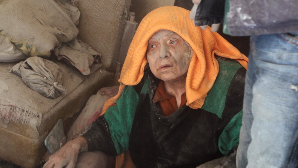 A woman, who survived an airstrike, sits amid the damage in the rebel held area of Old Aleppo