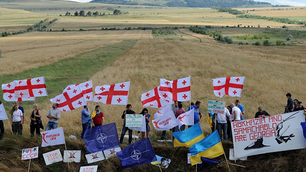 Members of Georgian NGOs, waving national flags of Georgia, take part in a rally against what they claim is a de facto annexation by Russia of the Georgian territories, in the village of Khurtaveli, c