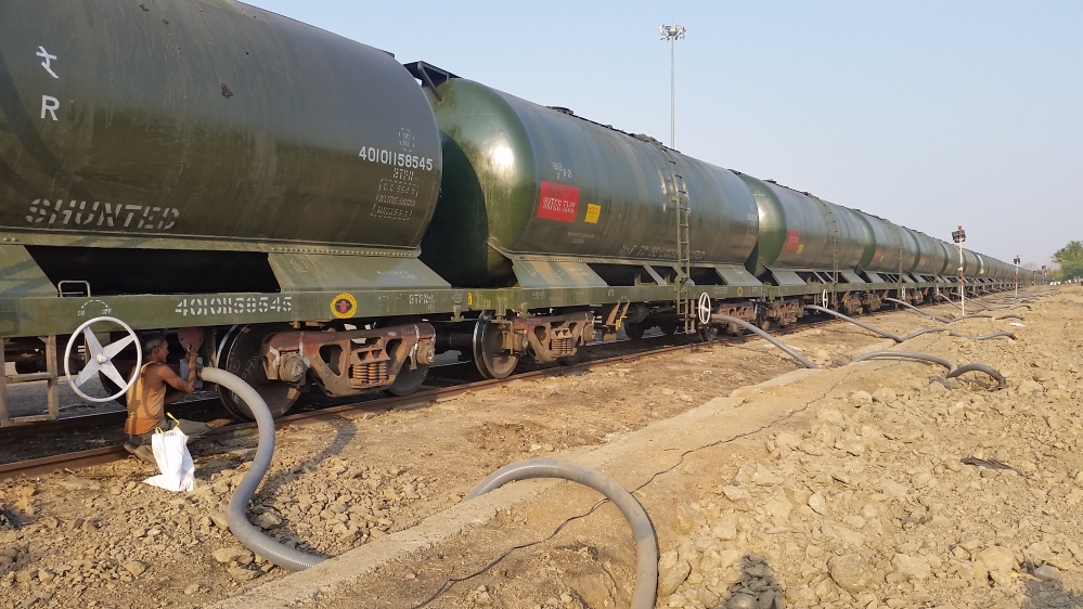 Workers hook up pipes to drain a train load of water from a nearby dam [Faiz Jamil/Al Jazeera]