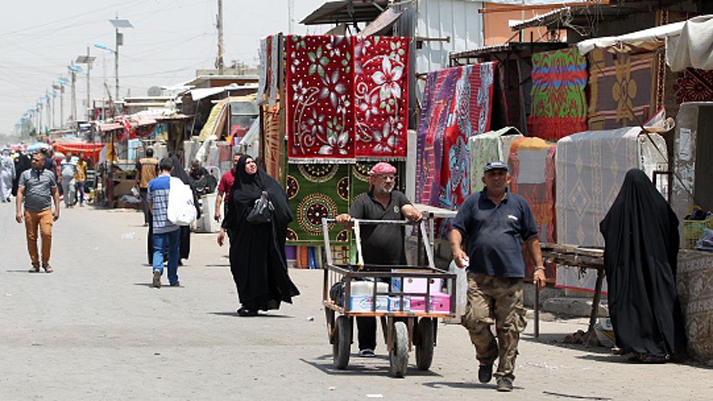 Iraqis walk past stalls at Oraiba market, a day after it was struck by a car bomb attack in the Sadr City area of northern Baghdad [AFP]