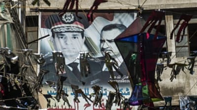 Portraits of Egyptian President Abdel Fattah el-Sisi and late president Gamal Abdel Nasser are seen on a wall in Cairo [Getty]