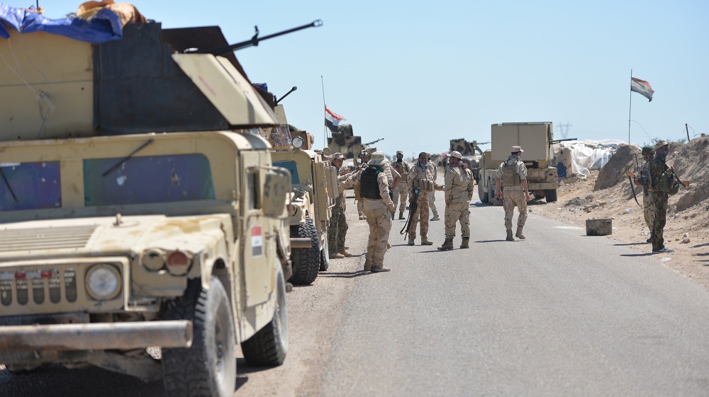 Iraqi soldiers with Shiite fighters gather on the outskirts of Fallujah