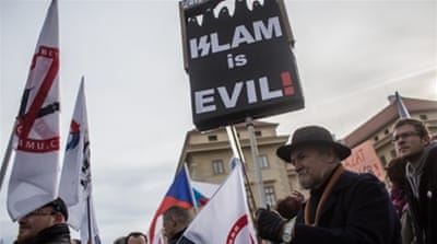 A man holds up placard during an anti-Islam protest in Prague, Czech Republic [Getty]