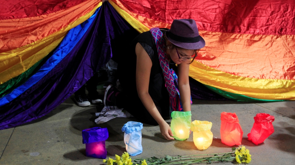 A gay rights activist places a candle during a rally in Cali, Colombia, in support of the victims of the Orlando Pulse nightclub shooting