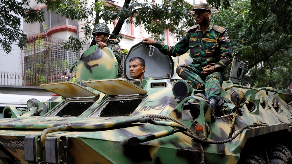 Army soldiers atop an armored military vehicle drive near the Holey Artisan restaurant after Islamist militants attacked the upscale cafe in Dhaka