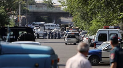 Policemen block a street after a group of armed men seized a police station along with an unknown number of hostages [Reuters]