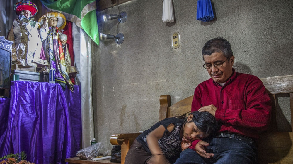 Don Juan and his niece in one of the 12 shrines around Santiago Atitlan. Each shrine is maintained by a member of a Catholic brotherhood or Confradia [Gabriela Campos/Al Jazeera] 