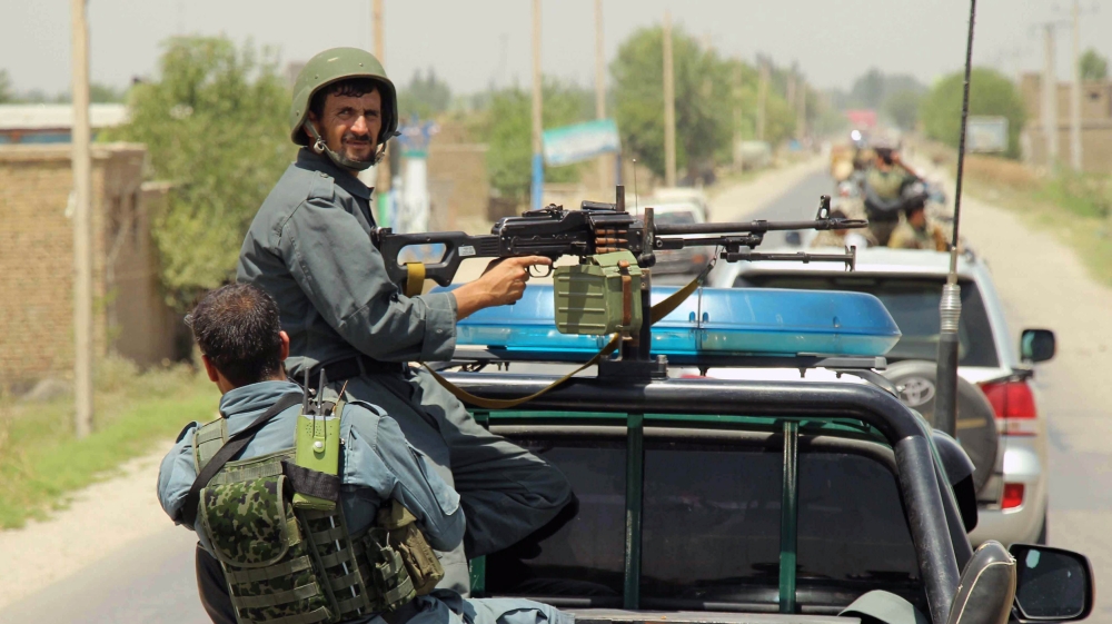 Afghan policemen patrol outside of Kunduz city