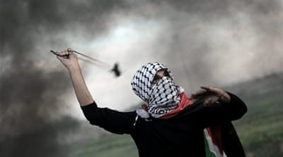 A Palestinian man uses a slingshot to launch stones at Israeli troops during clashes between Palestinians and Israeli troops along the border between Gaza strip and Israel [EPA]