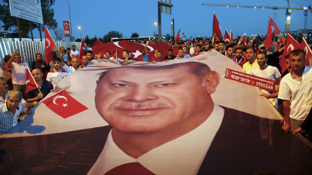 Pro-government demonstrators hold a giant Turkish national flag during a march towards the Asian side of the Bosphorus Bridge in Istanbul