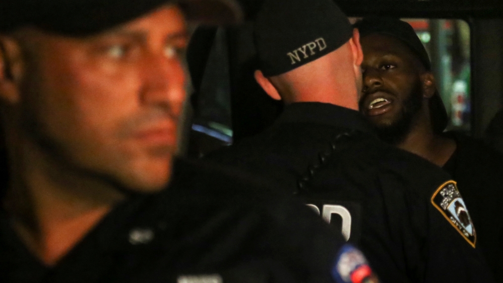 
A protester is loaded into a NYPD police car after being arrested in Manhatten [Bria Webb/Reuters]
