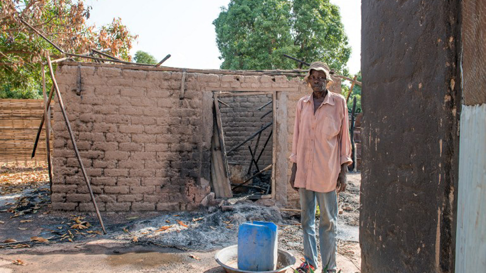 A man searches for belongings to salvage in a burned down house in Nazareth, on the outskirts of Wau after fighting in Wau displaced thousands of civilians [Charles Lomodong/AFP]