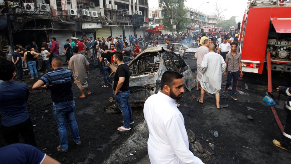 People gather at the site of a suicide car bomb in the Karrada shopping area, in Baghdad, Iraq