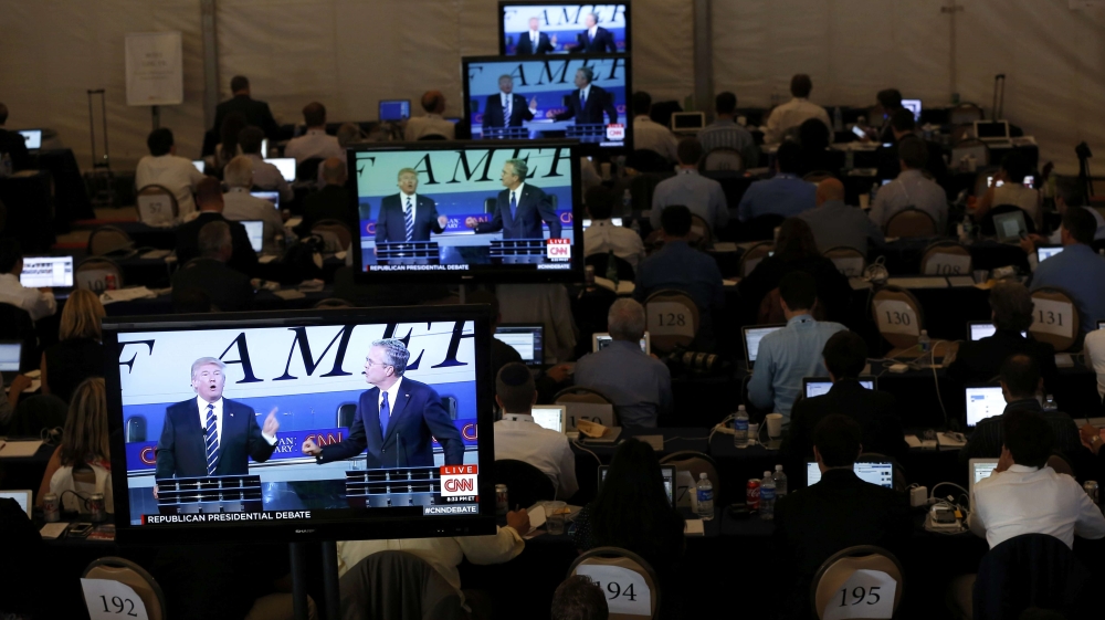 Members of the news media watch on TV monitors in the media center as U.S. presidential candidates Trump and Bush debate during the second Republican debate of the 2016 U.S. presidential campaign at t