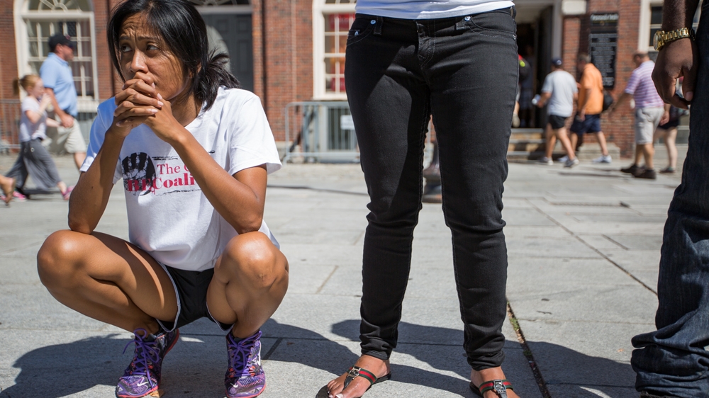 Marie Nuon, left, listens to Nia Evans speak outside Faneuil Hall [Carolyn Bick/Al Jazeera]  
