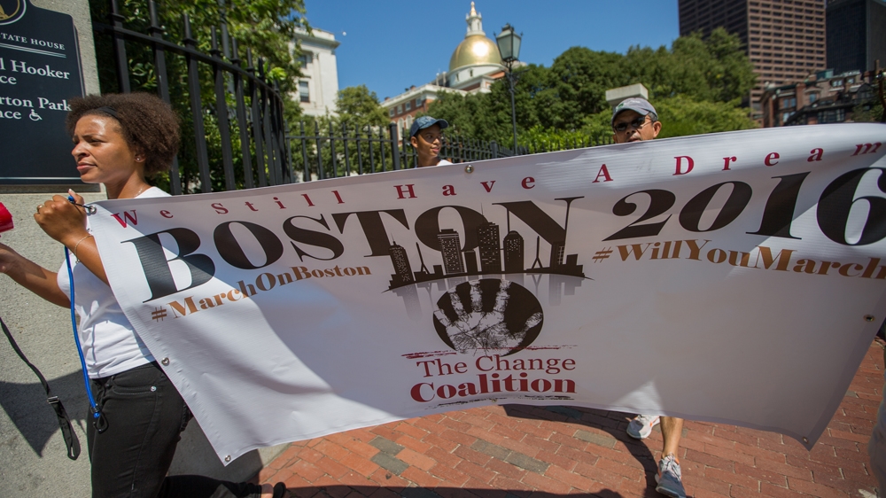 Lindsay Ladd, left, holds The Change Coalition's sign, as the group marches down the Freedom Trail   [Carolyn Bick/Al Jazeera]   