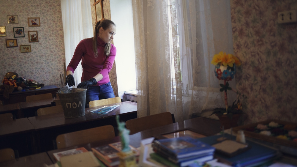 A teacher cleans her classroom of glass in May 2015. Almost all of the teachers are female. When we first began following the school, the teachers told us that only three of them had fled. But by the end of the year, most had left [Kyrre Lien/Al Jazeera] 