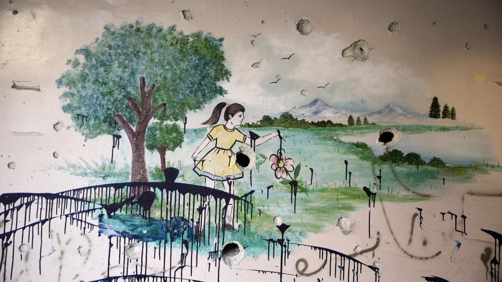 A damaged wall of a school is pictured in rebel-held Ain Tarma