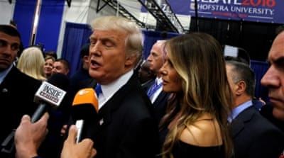 Donald Trump, with his wife Melania, talks to reporters in the spin room after his first debate against Hillary Clinton [Reuters]