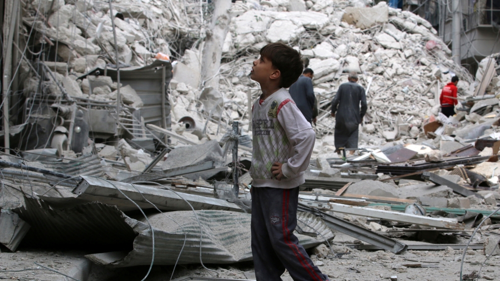 A boy inspects a damaged site after airstrikes on the rebel held Tariq al-Bab neighbourhood of Aleppo