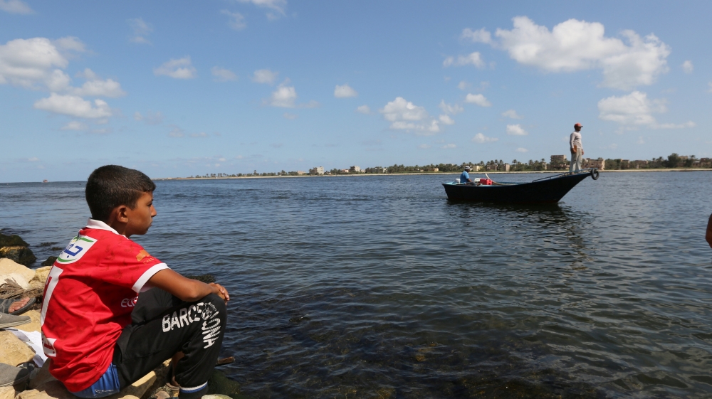 A relative of a missing person from a capsized boat in the Mediterranean Sea looks on, in Al-Beheira