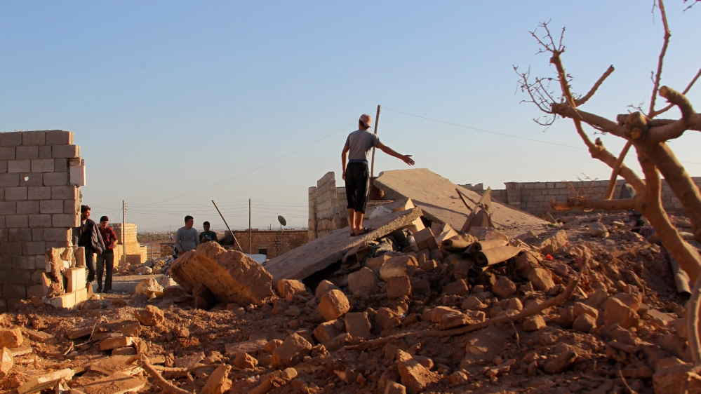People inspect a damaged site after an airstrike on the rebel held Owaijel village, west of Aleppo city, Syria [REUTERS]