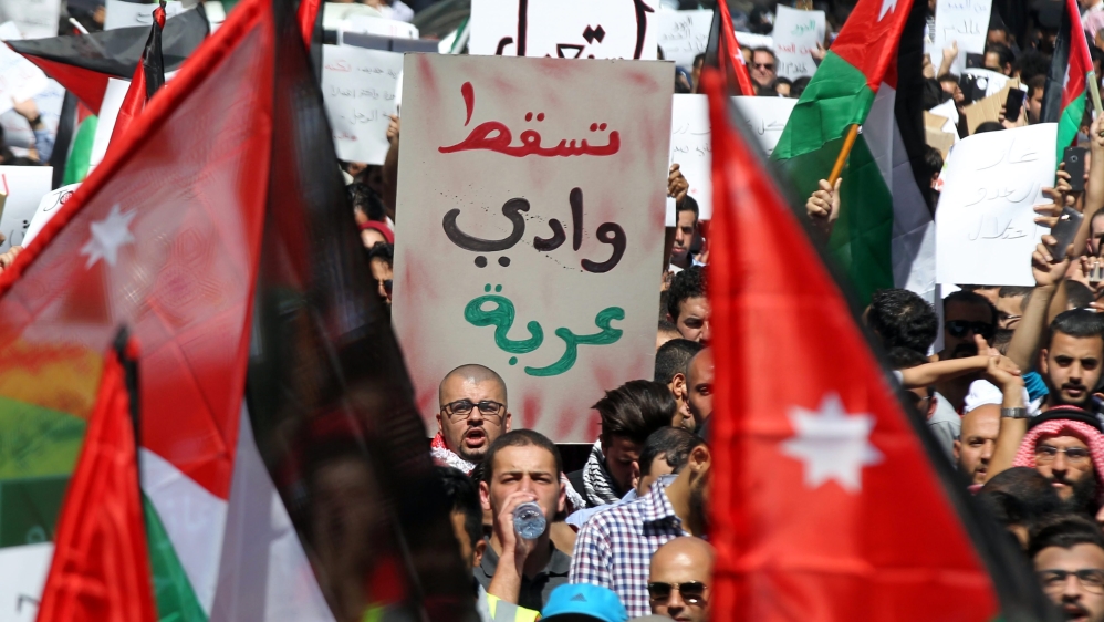 Protesters hold up a sign reading 